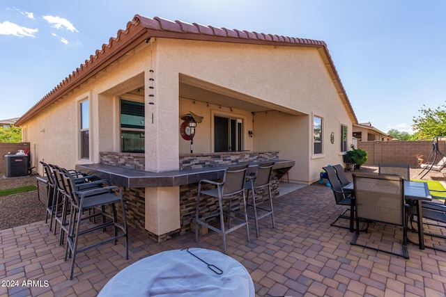 view of patio / terrace featuring exterior bar and cooling unit