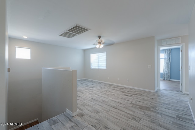 unfurnished room featuring ceiling fan, light hardwood / wood-style floors, and a wealth of natural light