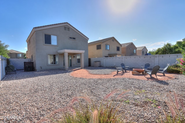 rear view of property featuring a patio area and an outdoor fire pit