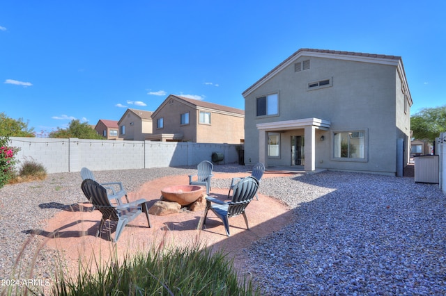 back of house with a fire pit and a patio area