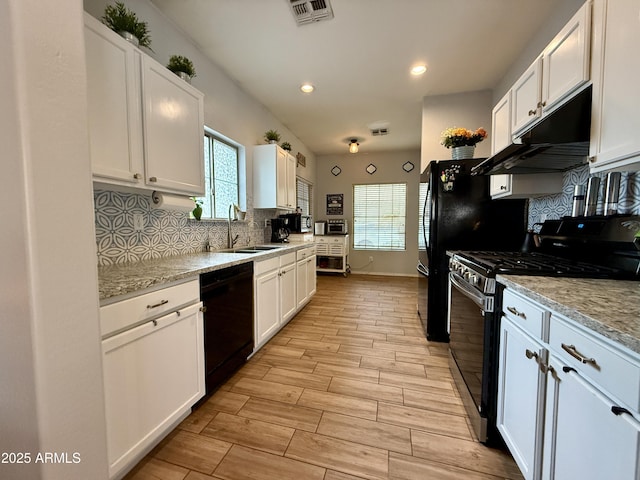 kitchen with white cabinetry, dishwasher, under cabinet range hood, and gas range oven