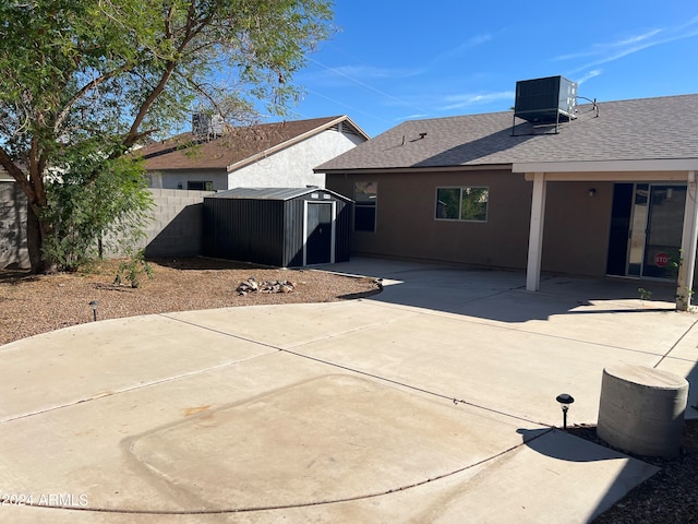 rear view of property featuring a patio area, central AC, and a storage unit