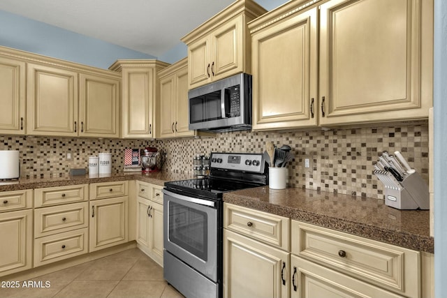 kitchen with light tile patterned floors, backsplash, and appliances with stainless steel finishes