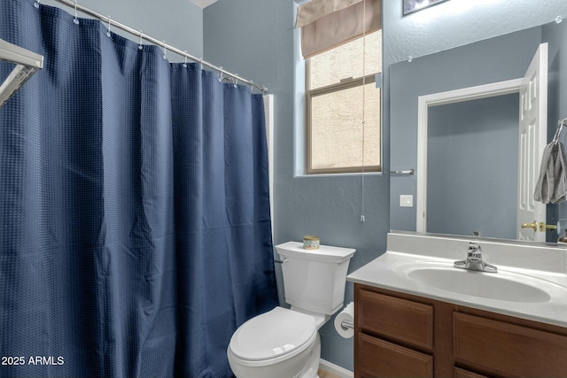 bathroom featuring vanity, curtained shower, and toilet