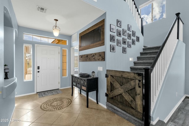 foyer with a towering ceiling and tile patterned floors