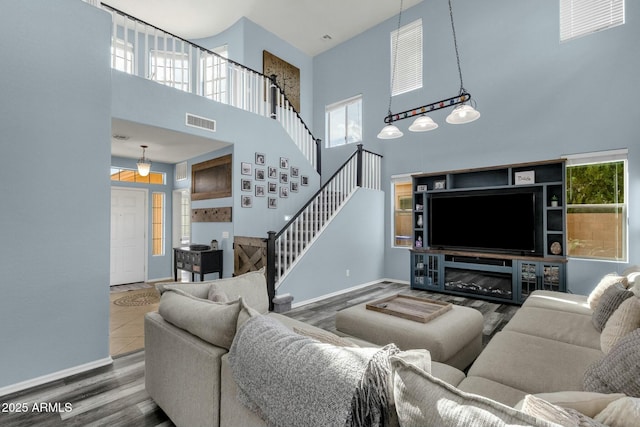 living room featuring wood-type flooring and a high ceiling