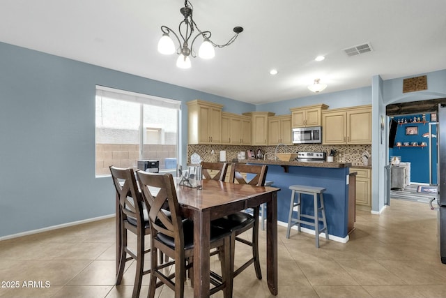 tiled dining room featuring a chandelier