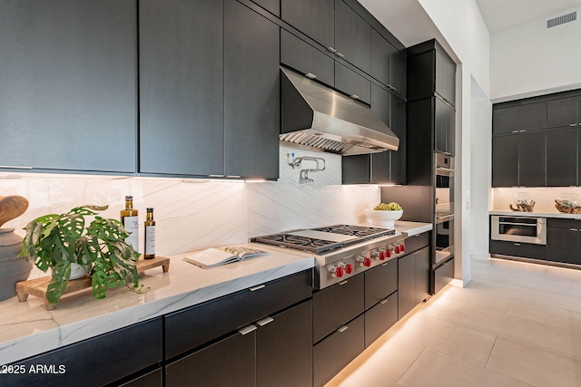 kitchen with tasteful backsplash, light stone countertops, and appliances with stainless steel finishes