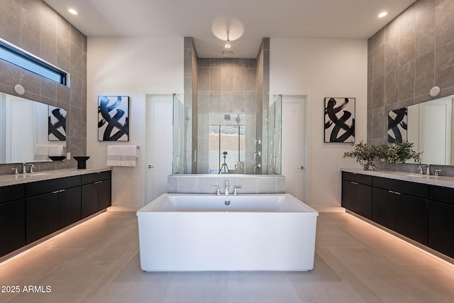 bathroom with vanity, a towering ceiling, and plus walk in shower