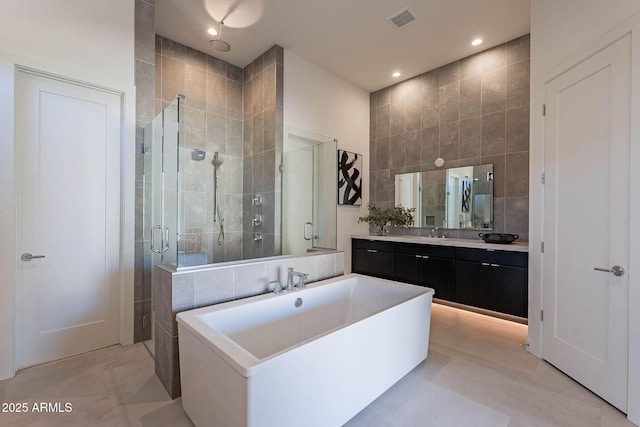 bathroom with independent shower and bath, vanity, tile patterned flooring, and tile walls