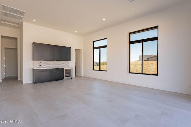 unfurnished living room with sink and beverage cooler