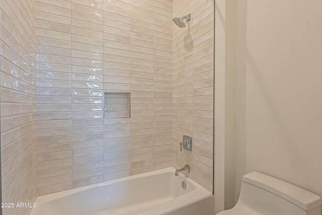 bathroom with tiled shower / bath combo and toilet