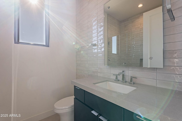 bathroom with vanity, backsplash, and toilet