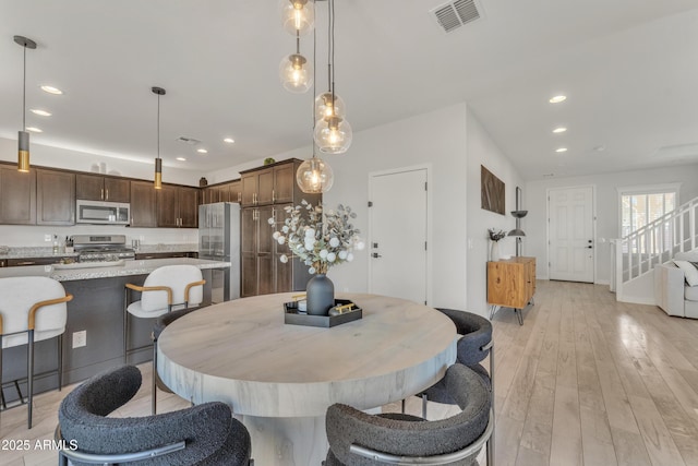 dining area with stairs, light wood finished floors, visible vents, and recessed lighting