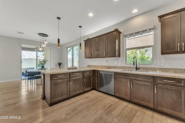 kitchen with visible vents, a sink, light wood-type flooring, dishwasher, and a peninsula