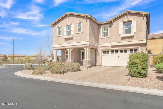 view of front of home with a garage, decorative driveway, and stucco siding