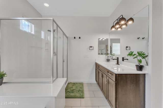 full bath featuring a stall shower, tile patterned flooring, vanity, and baseboards