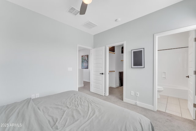 bedroom featuring baseboards, visible vents, a walk in closet, and carpet flooring