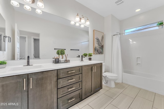 bathroom featuring toilet, double vanity, a sink, and visible vents