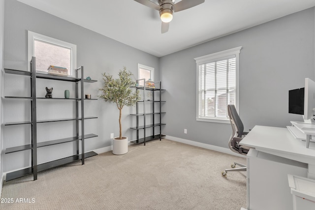 carpeted office with a ceiling fan and baseboards