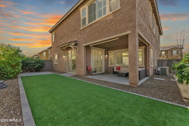 back of house at dusk featuring a patio, central air condition unit, a fenced backyard, and stucco siding