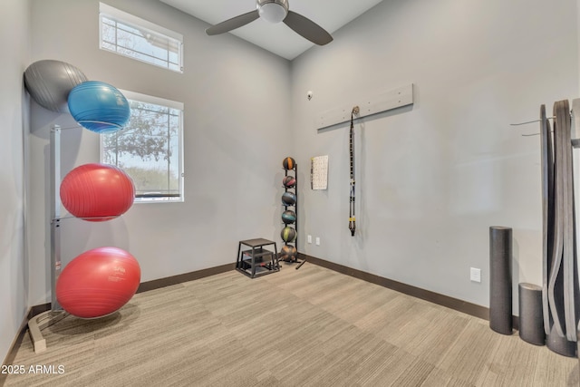 exercise room featuring carpet, baseboards, and a ceiling fan