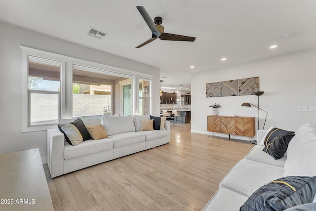 living room with visible vents, ceiling fan, light wood-style flooring, and recessed lighting