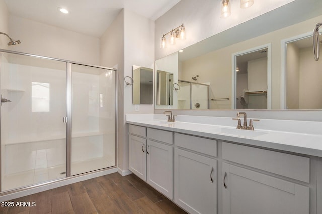 bathroom with vanity, wood-type flooring, and a shower with door