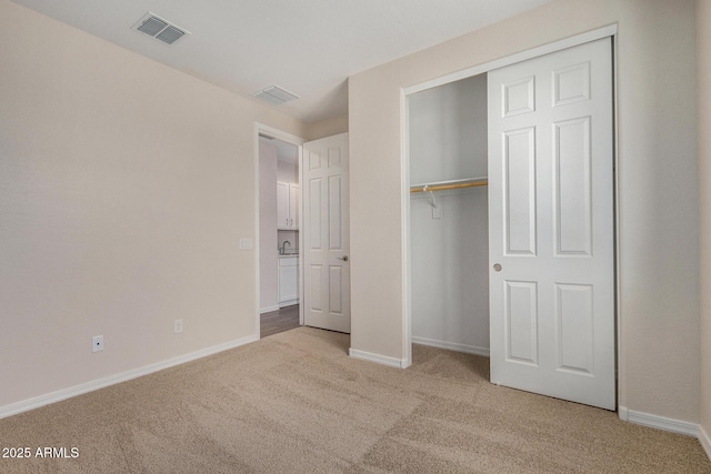 unfurnished bedroom featuring light colored carpet and a closet