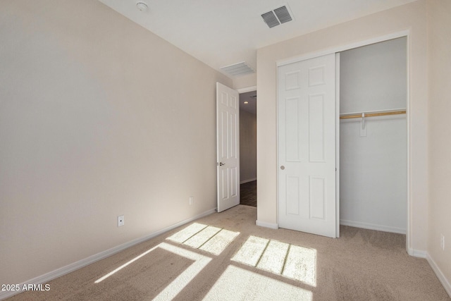 unfurnished bedroom featuring light carpet and a closet