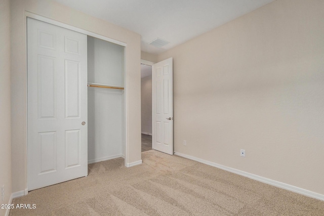 unfurnished bedroom featuring light colored carpet and a closet