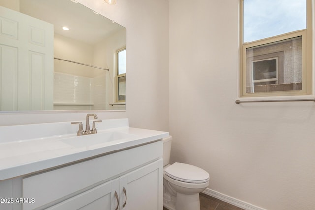 bathroom featuring vanity, a wealth of natural light, toilet, and walk in shower