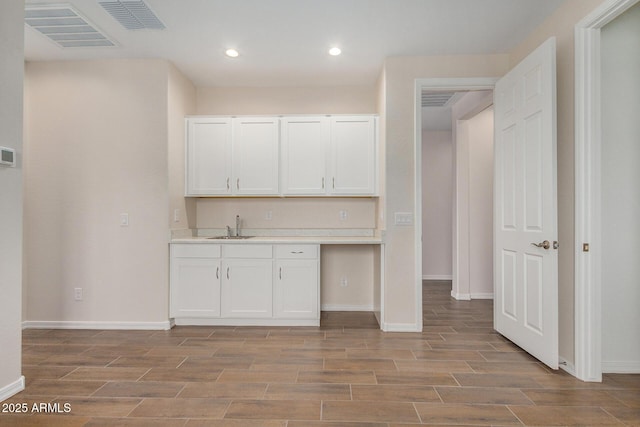 kitchen featuring white cabinetry and sink