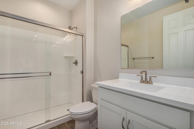 bathroom featuring vanity, hardwood / wood-style flooring, a shower with shower door, and toilet