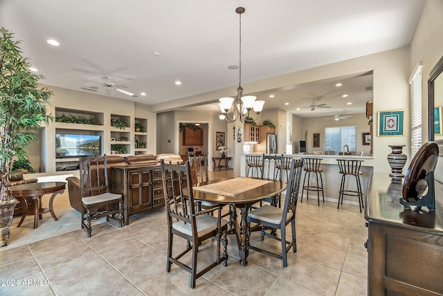 dining room with ceiling fan with notable chandelier, built in features, sink, and light tile patterned floors