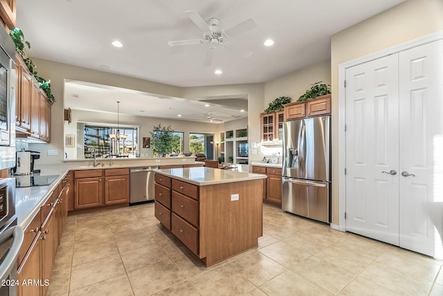 kitchen featuring pendant lighting, sink, ceiling fan, appliances with stainless steel finishes, and a kitchen island