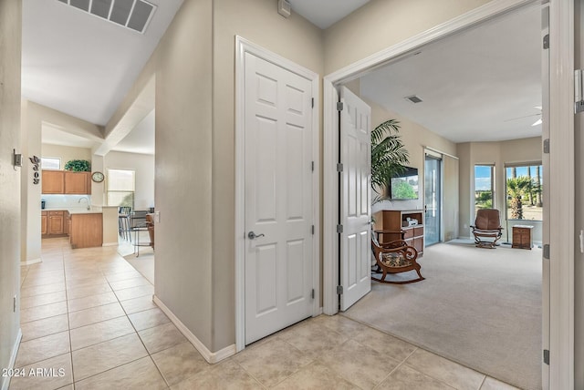 hallway featuring light colored carpet