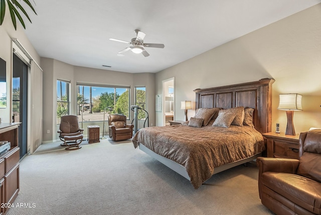 bedroom with ceiling fan, ensuite bathroom, and light carpet