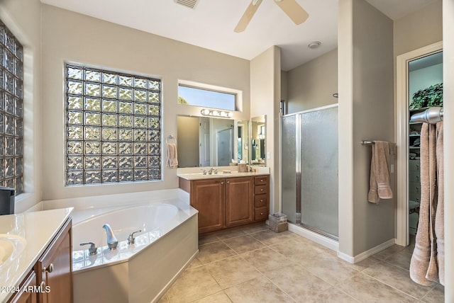 bathroom featuring tile patterned flooring, vanity, a healthy amount of sunlight, and plus walk in shower