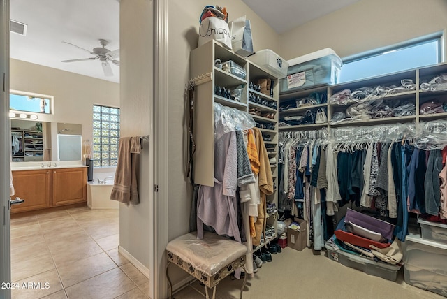 spacious closet with ceiling fan, sink, and light tile patterned flooring