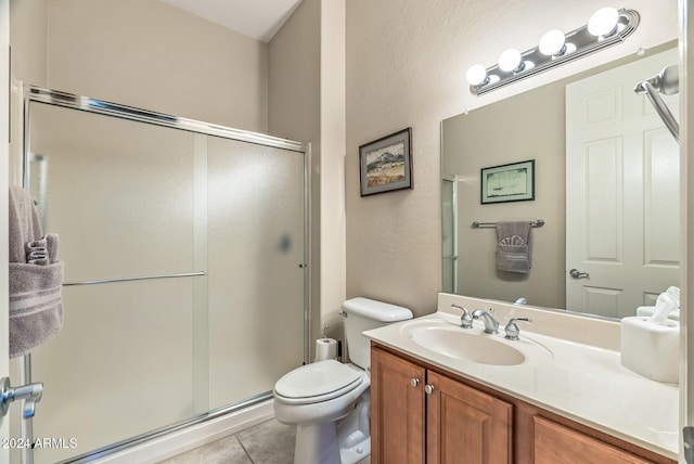 bathroom featuring toilet, vanity, tile patterned floors, and a shower with shower door