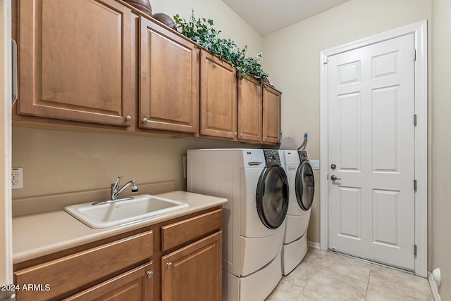 washroom featuring washer and clothes dryer, sink, light tile patterned floors, and cabinets