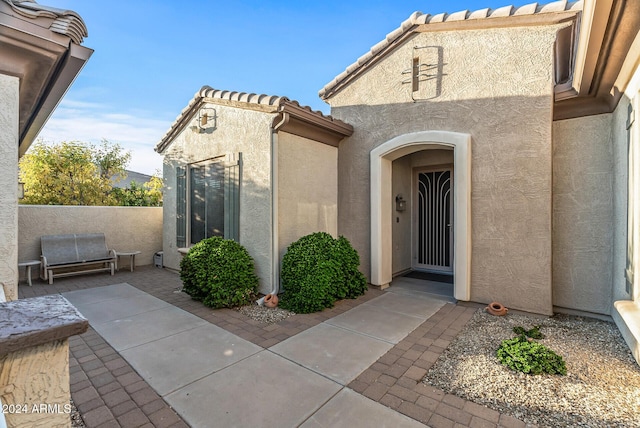 view of exterior entry featuring a patio area