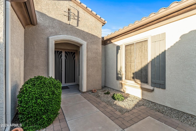 view of exterior entry featuring a patio