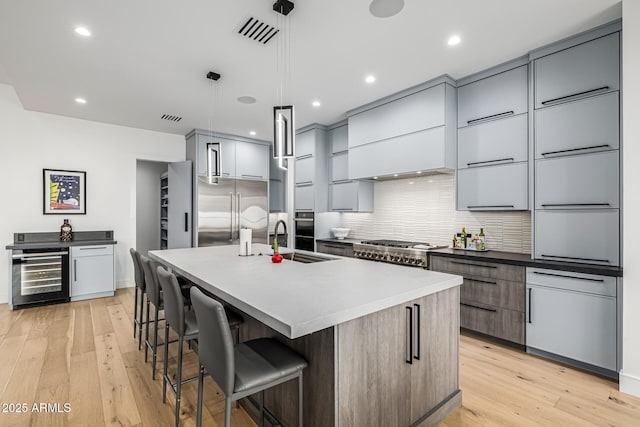 7851 N Central Ave, Phoenix, AZ 85020 - kitchen featuring beverage cooler, a sink, modern cabinets, backsplash, and a kitchen bar