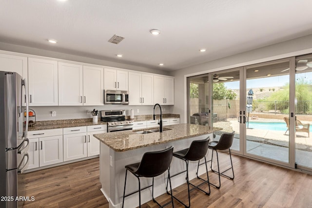 7858 W Fetlock Trl, Peoria, AZ 85383 - kitchen featuring appliances with stainless steel finishes, light stone counters, white cabinets, french doors, and recessed lighting