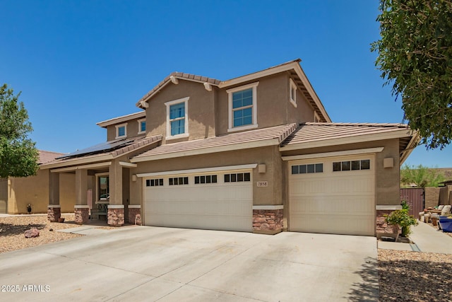 7858 W Fetlock Trl, Peoria, AZ 85383 - view of front of home with stone siding, roof mounted solar panels, driveway, an attached garage, and a tiled roof