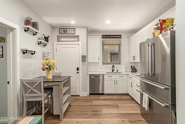 7858 W Fetlock Trl, Peoria, AZ 85383 - kitchen featuring stainless steel appliances, white cabinets, light wood-type flooring, decorative backsplash, and recessed lighting