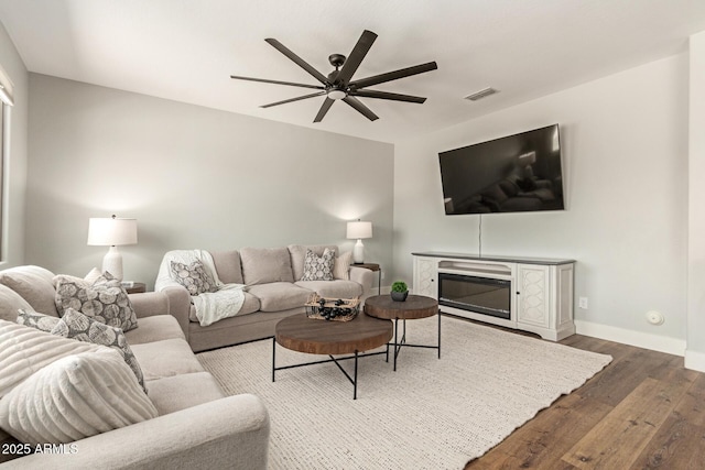7858 W Fetlock Trl, Peoria, AZ 85383 - living room featuring wood finished floors, ceiling fan, and a glass covered fireplace