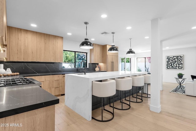 10360 N 98th St, Scottsdale, AZ 85258 - kitchen featuring visible vents, light brown cabinetry, modern cabinets, a breakfast bar area, and backsplash